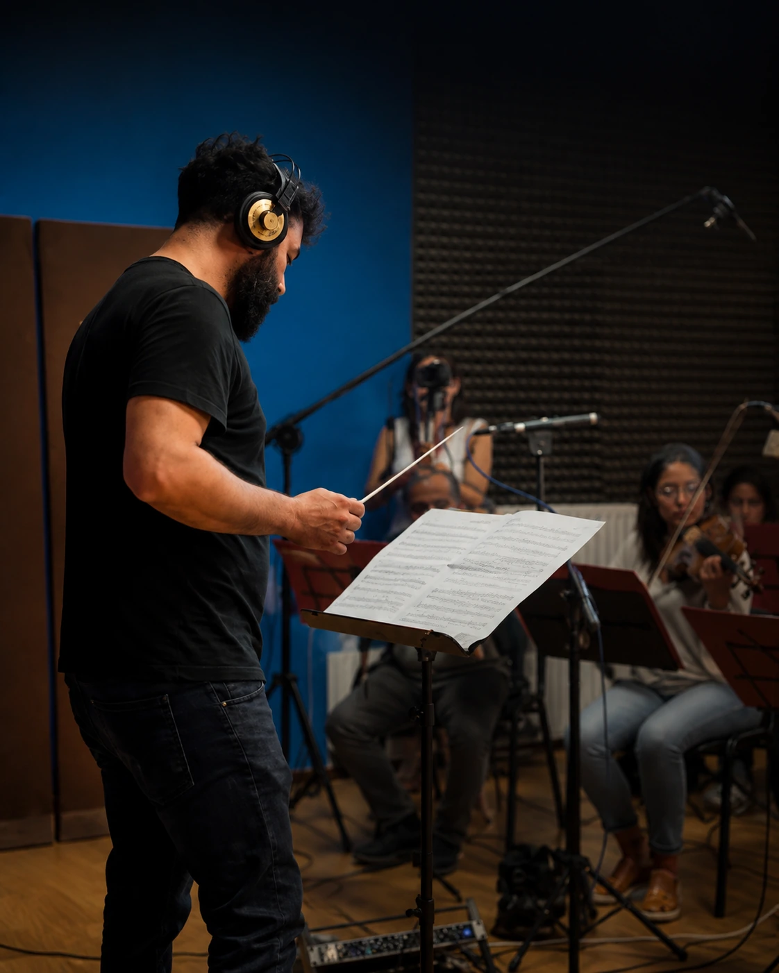 Pietro Gallo conducting musicians in a recording studio